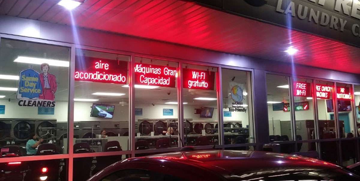 The lit storefront at night, seen from the parking lot