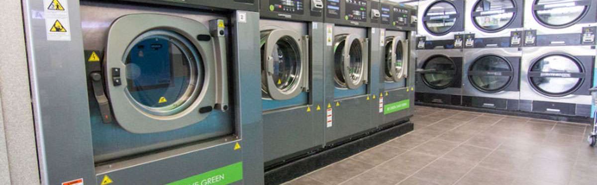 A row of large capacity Continental front load washers facing a wall of dryers